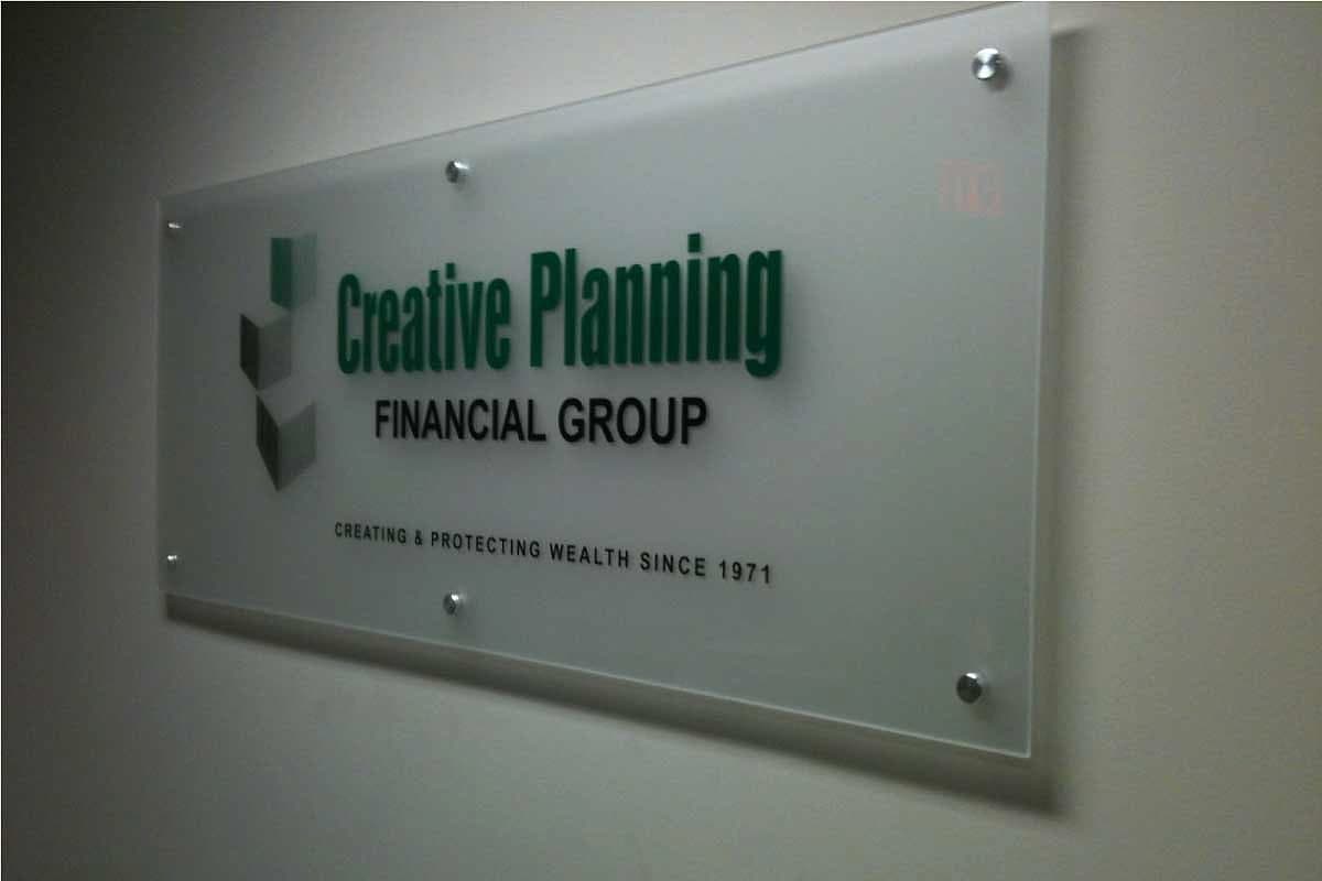 Frosted glass plaque with the Creative Planning Financial Group logo on polished standoff fixings