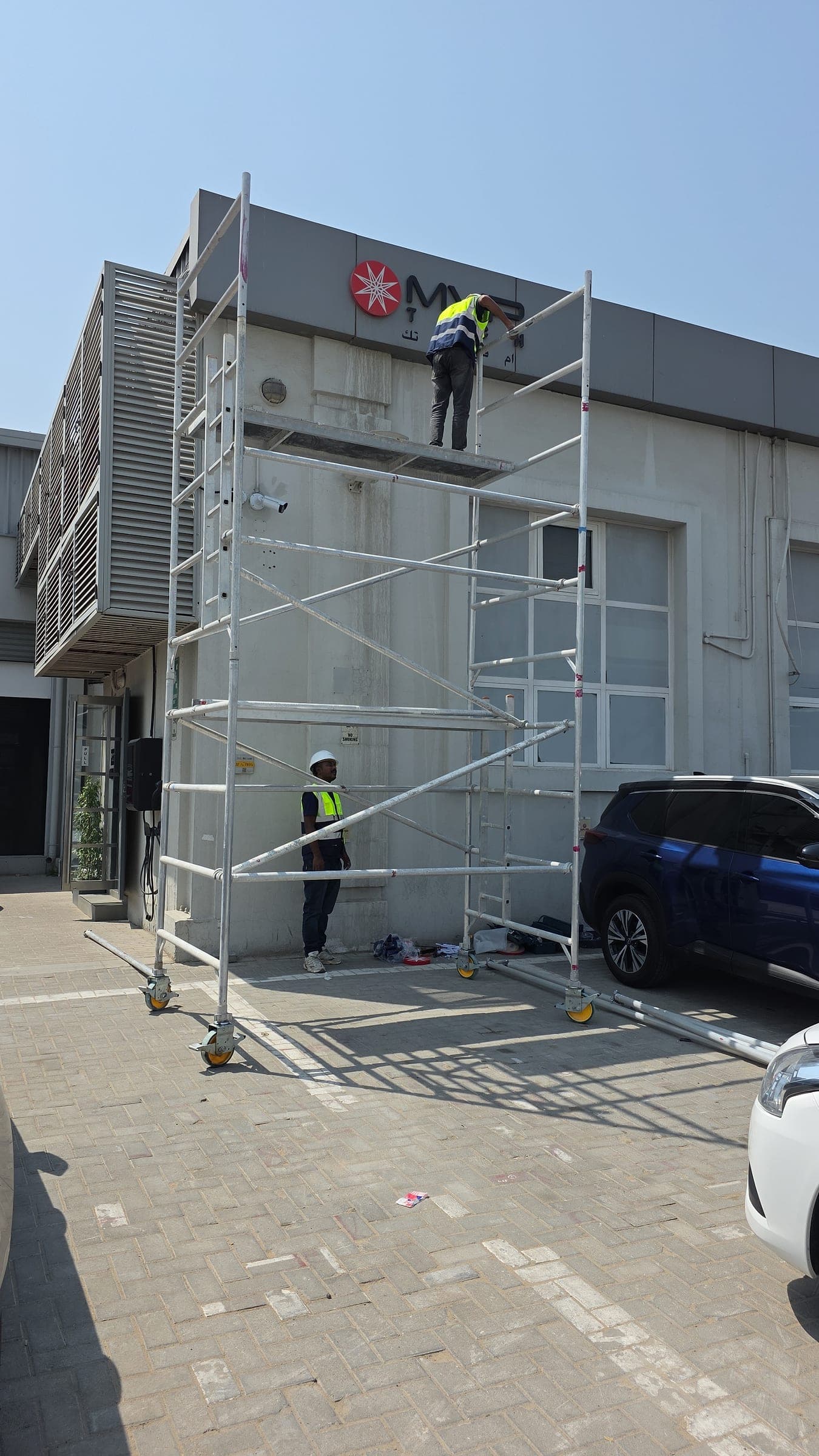 Technicians on a mobile scaffold changing the façade sign of the Convergint building