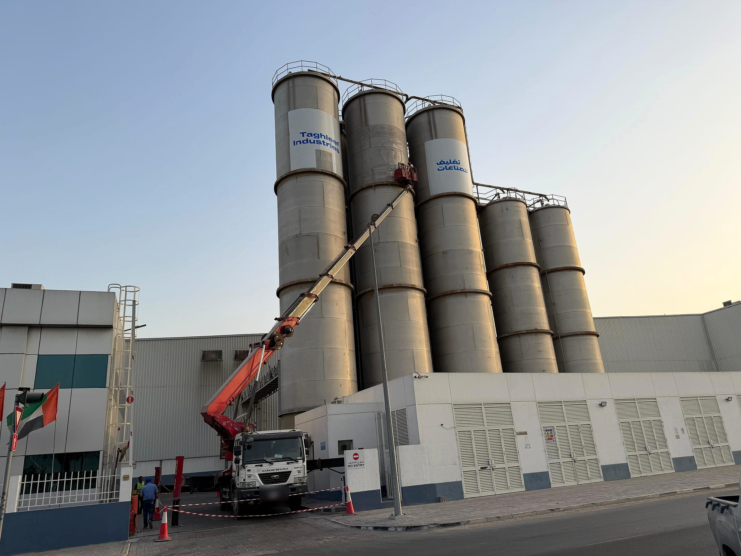 Crane lifting installers to apply graphics on Taghleef silos