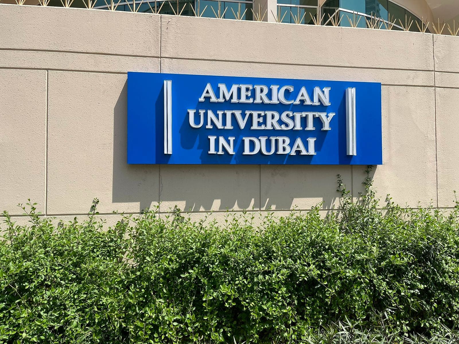 American University in Dubai sign with raised white letters on a blue panel