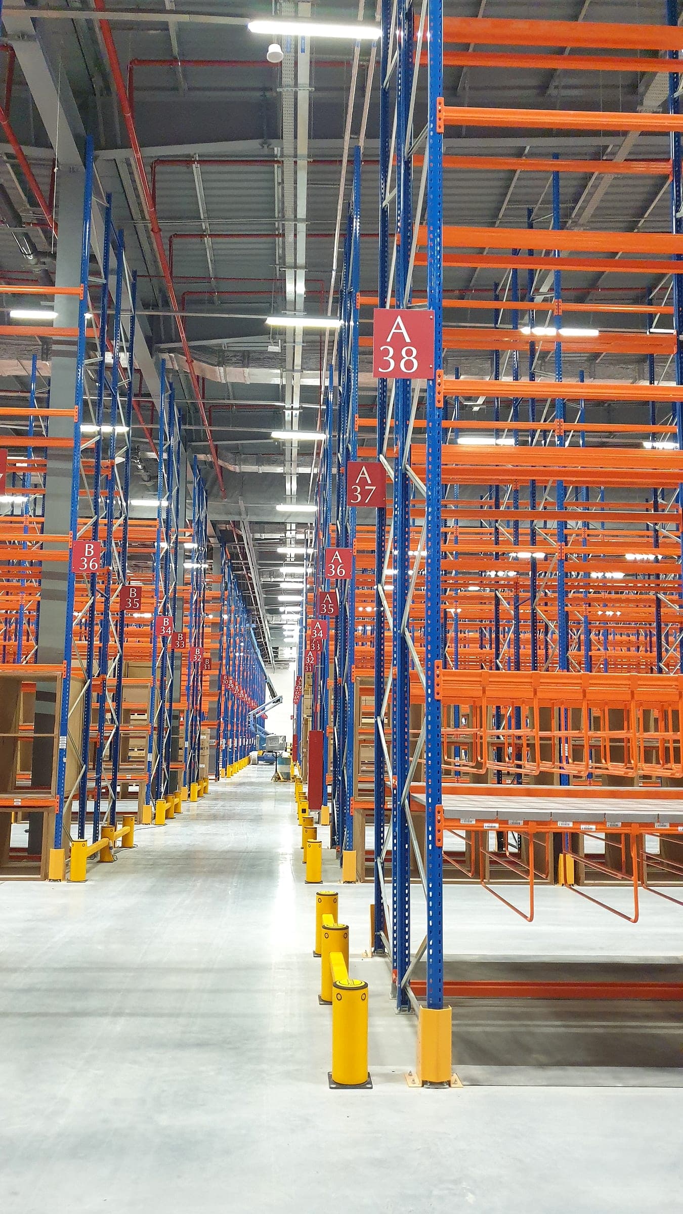 Red aisle marker signs hanging in a high-bay warehouse