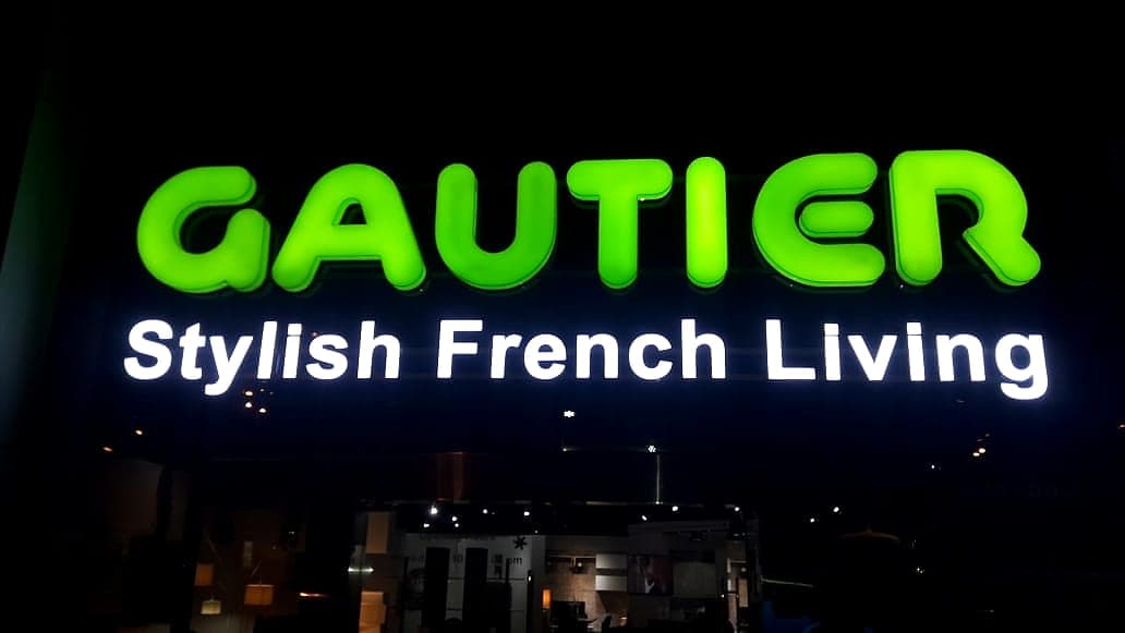 Green illuminated Gautier letters at night