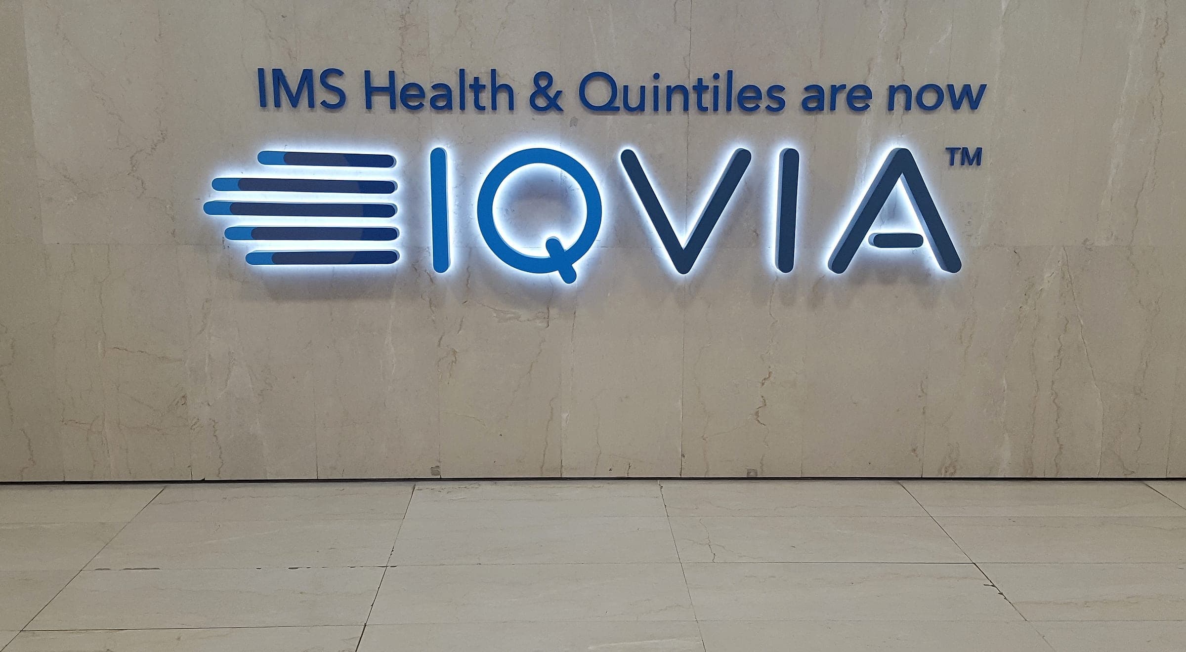 Halo-lit IQVIA logo on a marble reception counter