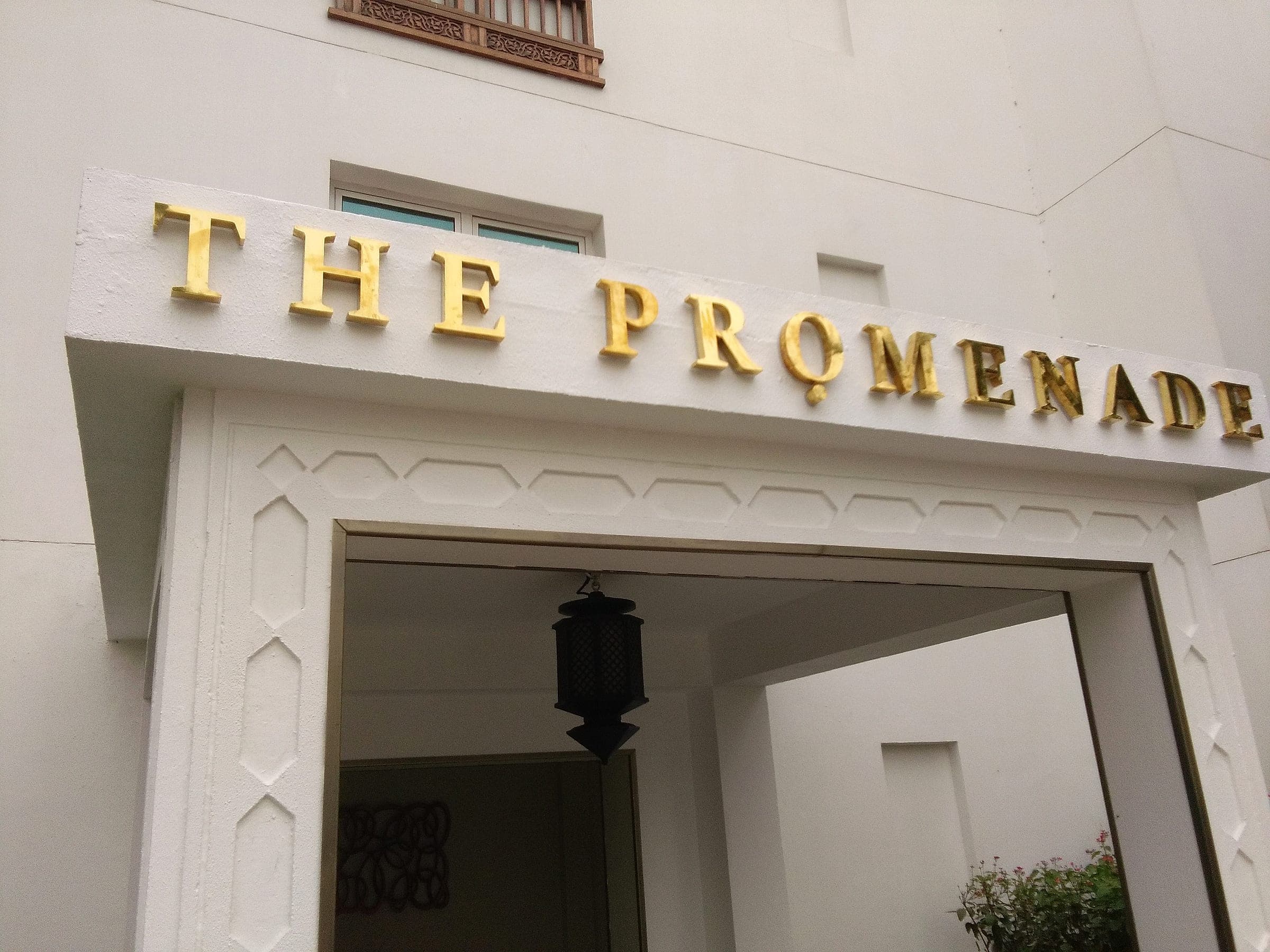 Gold 3D letters spelling The Promenade above an arched entrance