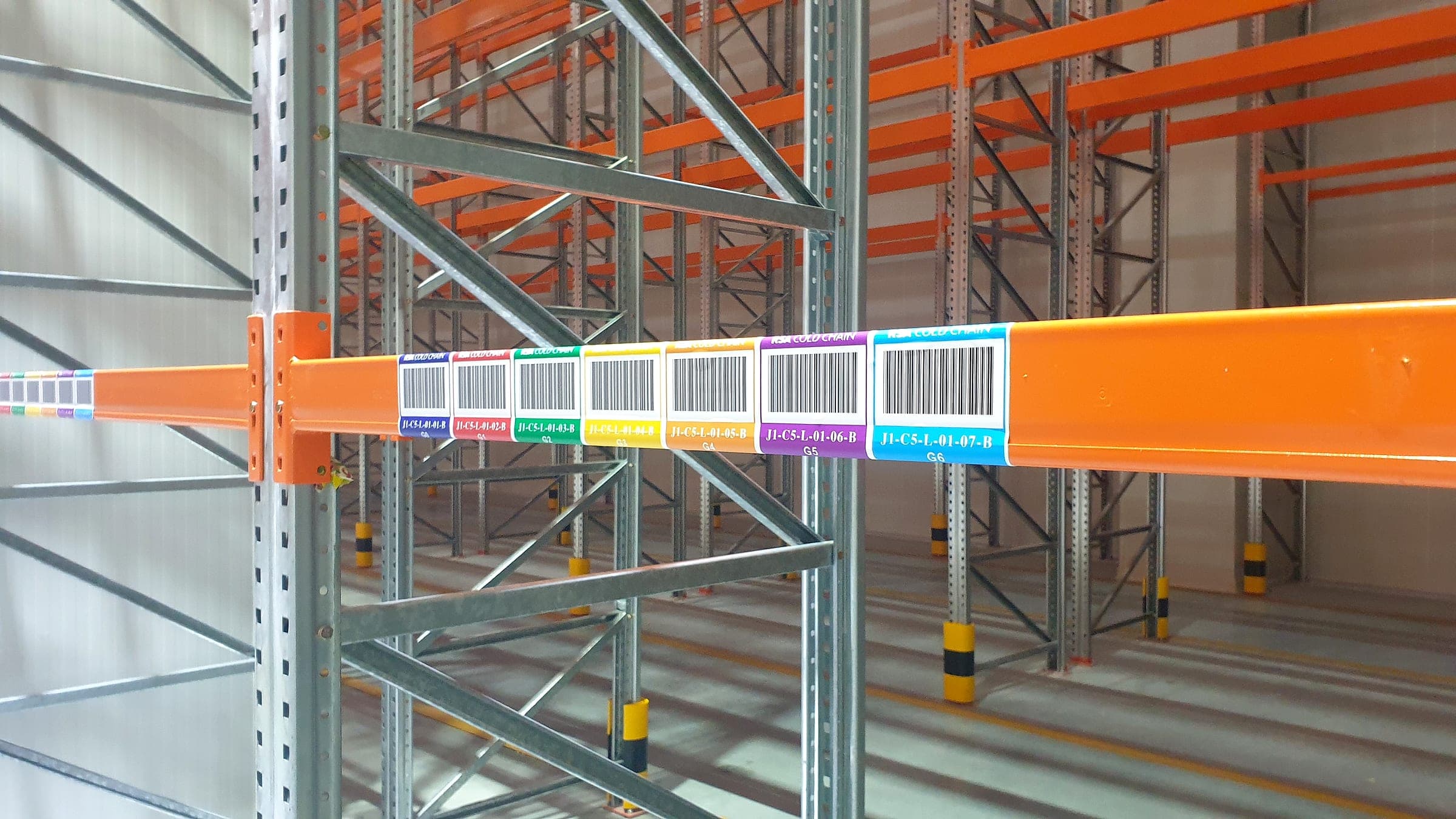 Colour-coded barcode location labels on warehouse racking beams