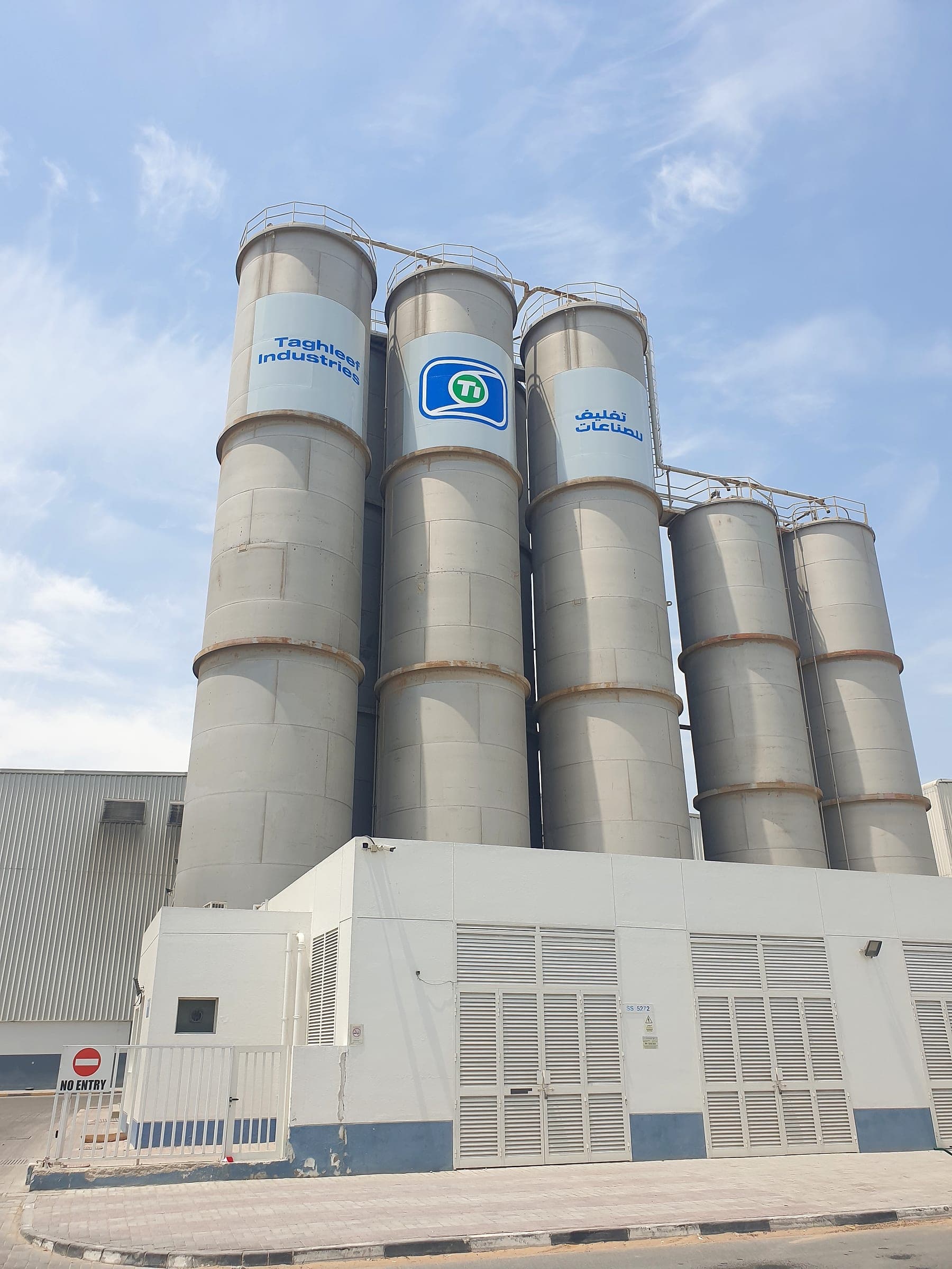 Taghleef Industries silos branded with logo graphics against a blue sky