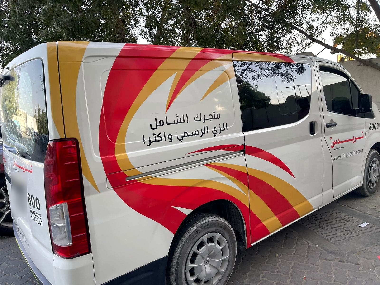 Toyota Hiace van wrapped in Threads red and gold branding